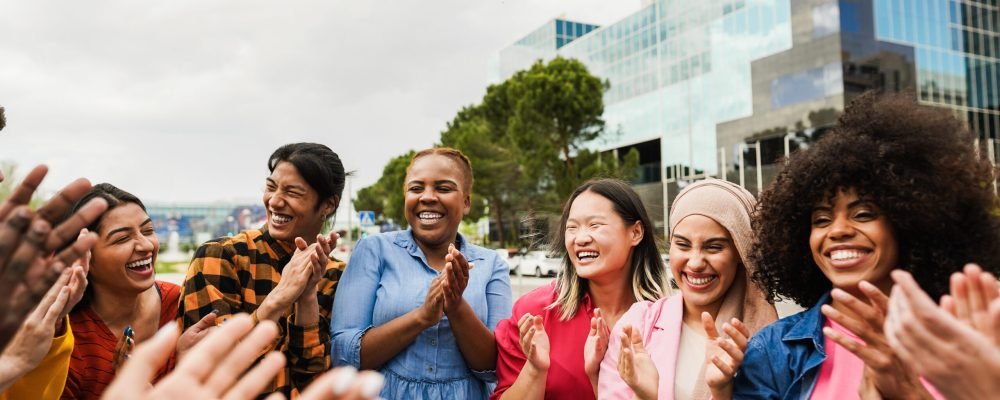 Young diverse people celebrating together outdoor - Focus on asian girl face